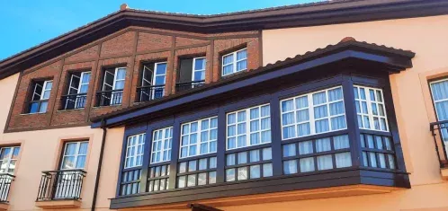 Detalle de la galería acristalada y la entrada del Hotel Rural Las Solanas de Escalante, una construcción tradicional cántabra con vistas al entorno natural