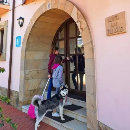 Familia entrando en un hotel dog friendly en Escalante, Cantabria, con su perro