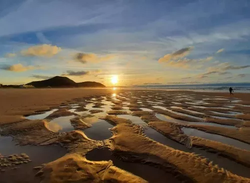 Playa de Berria en Santoña al atardecer, con marea baja y vistas al monte Buciero